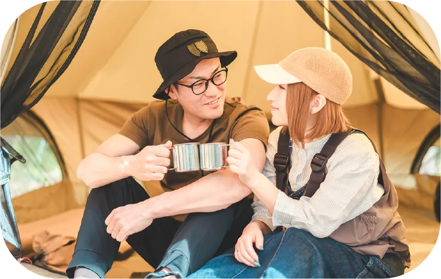 テントの中で乾杯する男女
