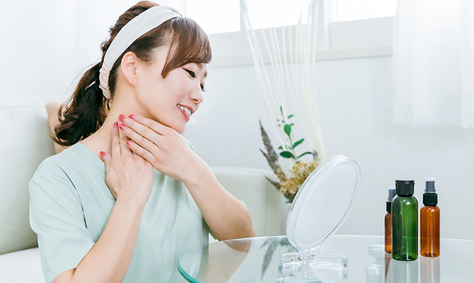 首のスキンケアをする女性