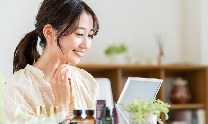 鏡を見て微笑む女性