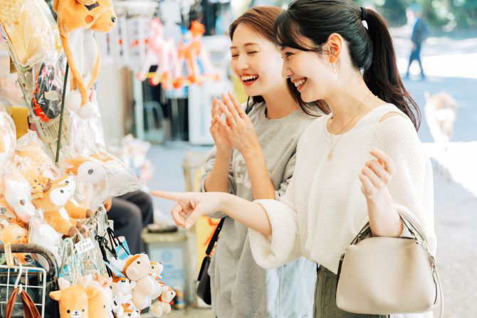 店先で楽しそうにぬいぐるみを選んでいる女性2人組