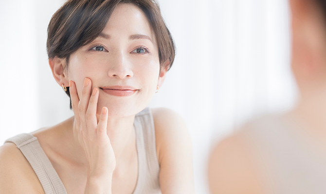 鏡で自分の顔を見る女性