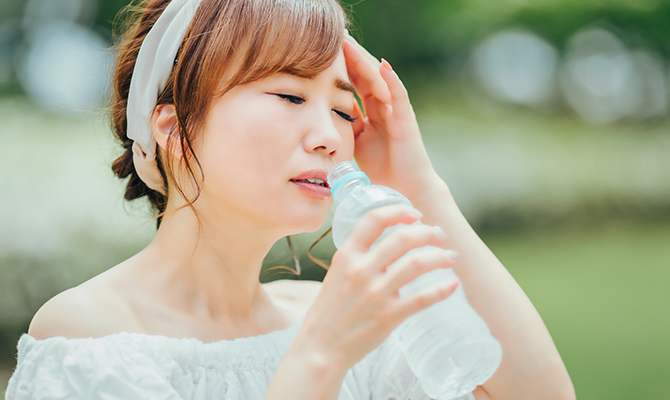 ペットボトルで水分補給をする女性