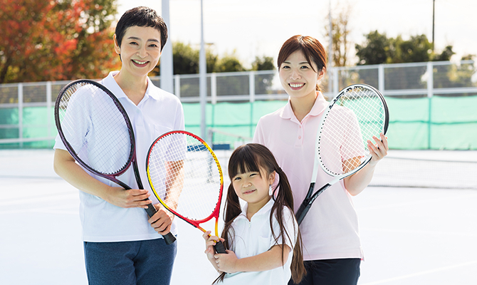 テニスラケットを持った3人の親子
