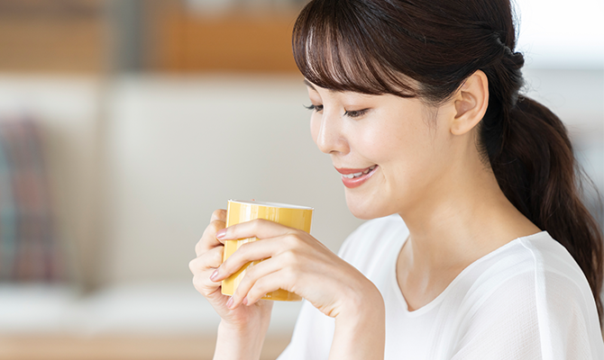 温かい飲み物を飲む女性
