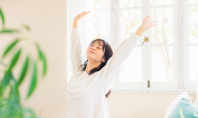 朝起きて伸びをする女性